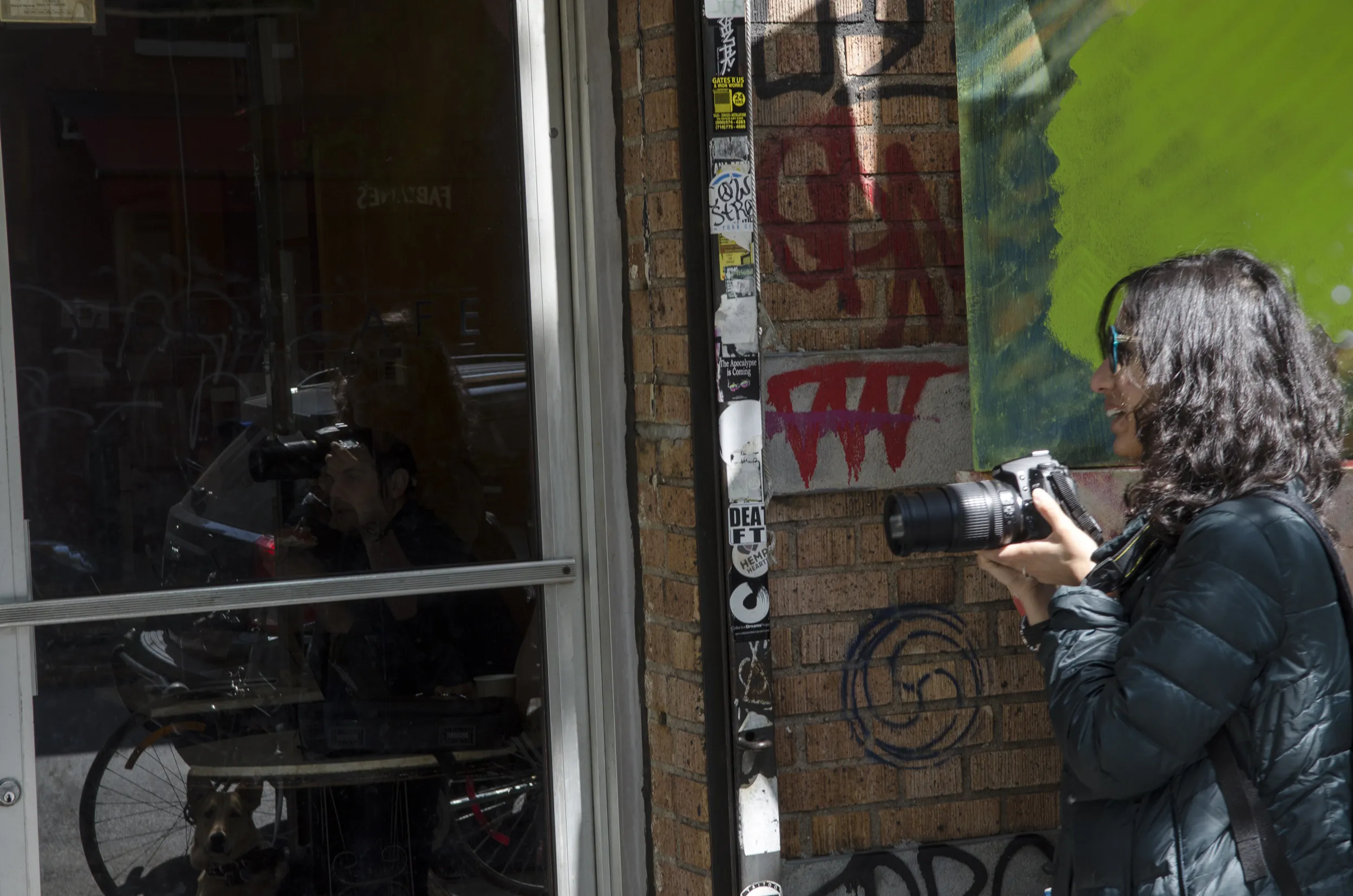 A lady holding a camera outside.