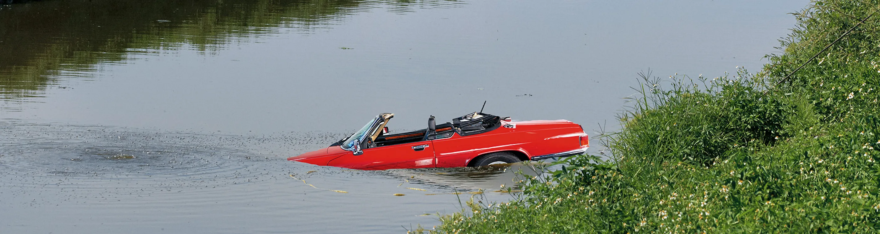 A car lays submerged in a river.