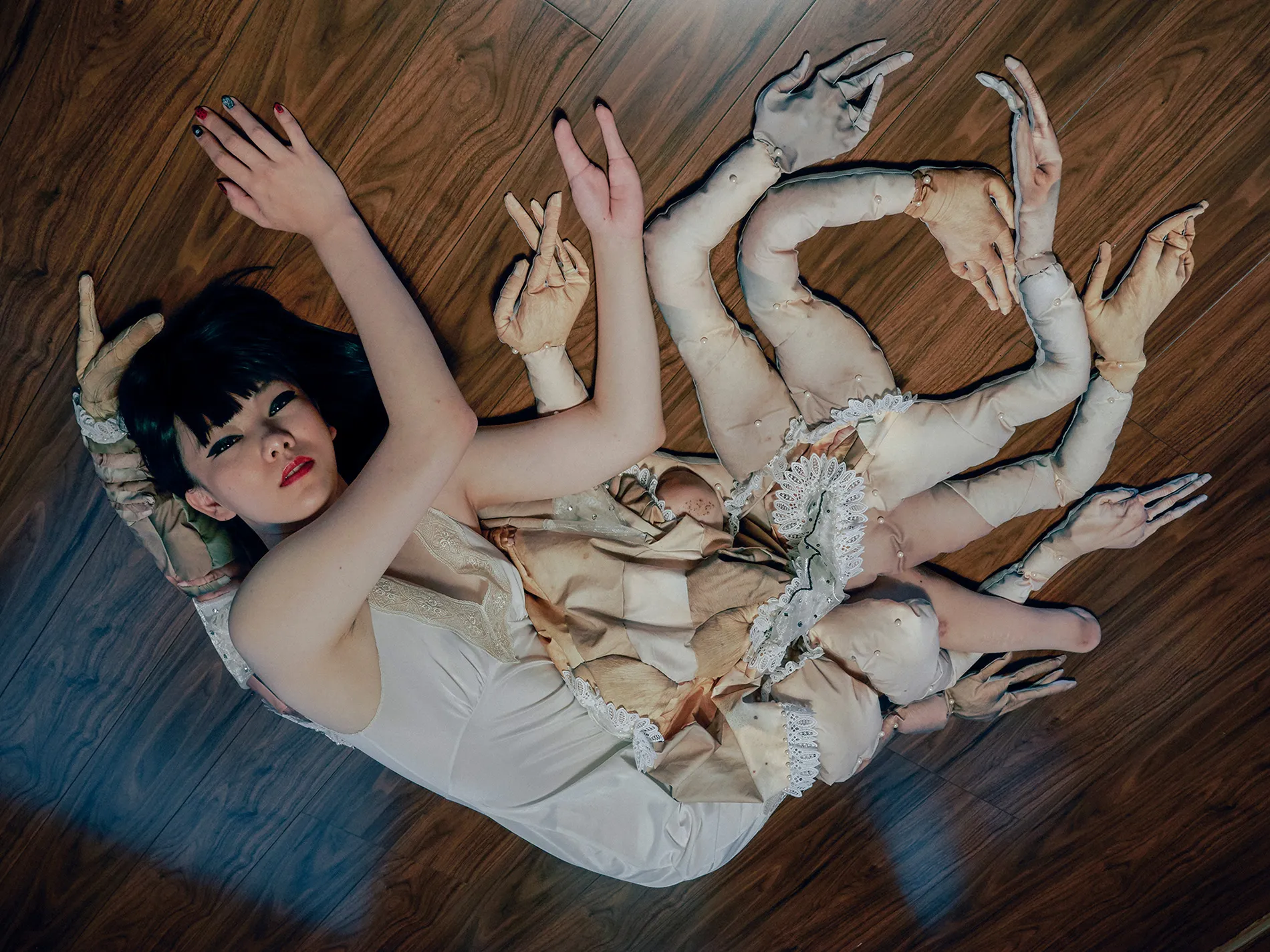 A woman on the floor with extra hands.
