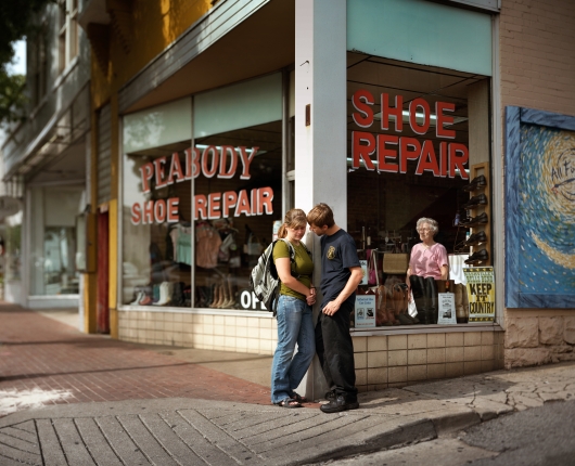 People standing in front of a shoe repair store.