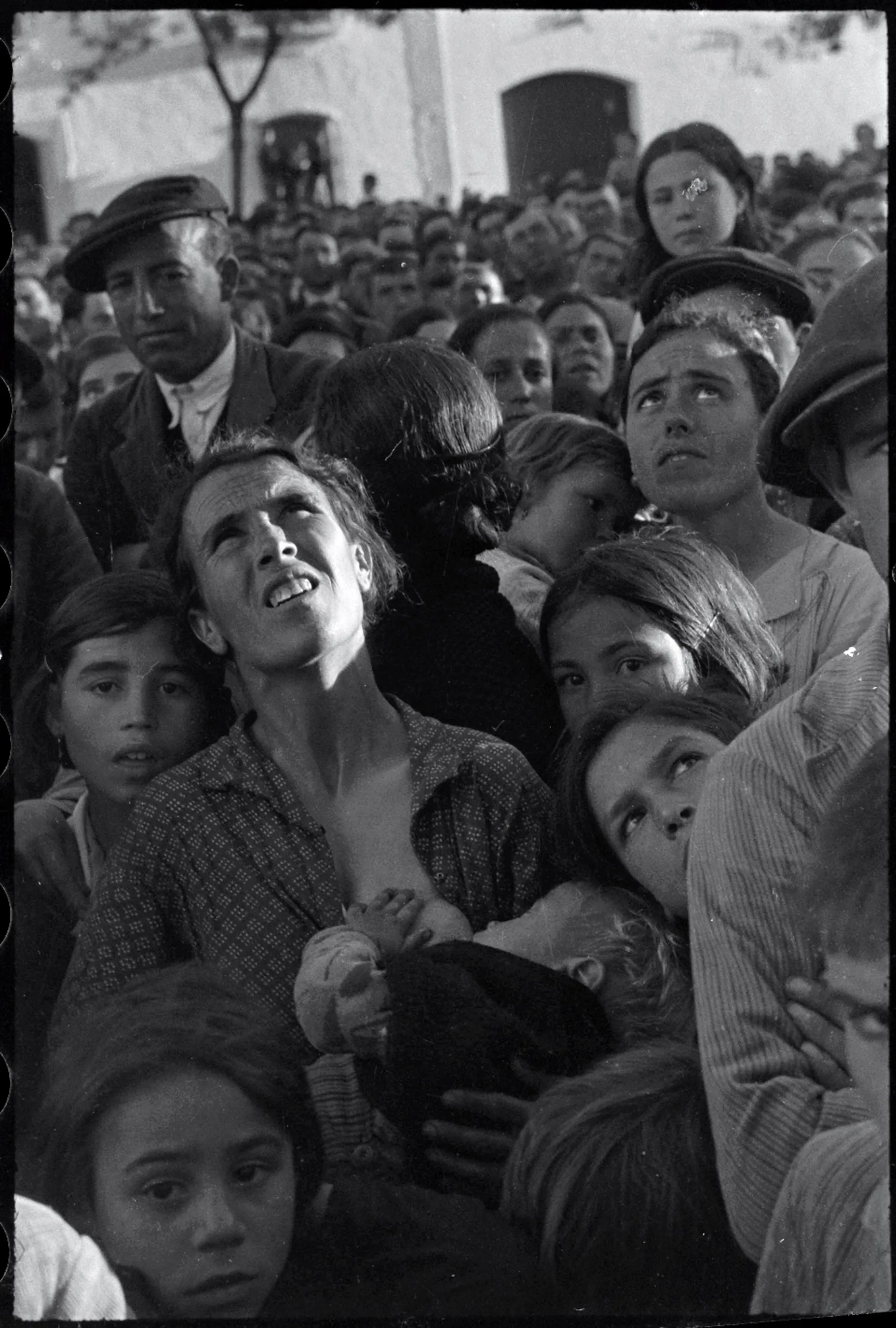 A crowd of people outside looking up.