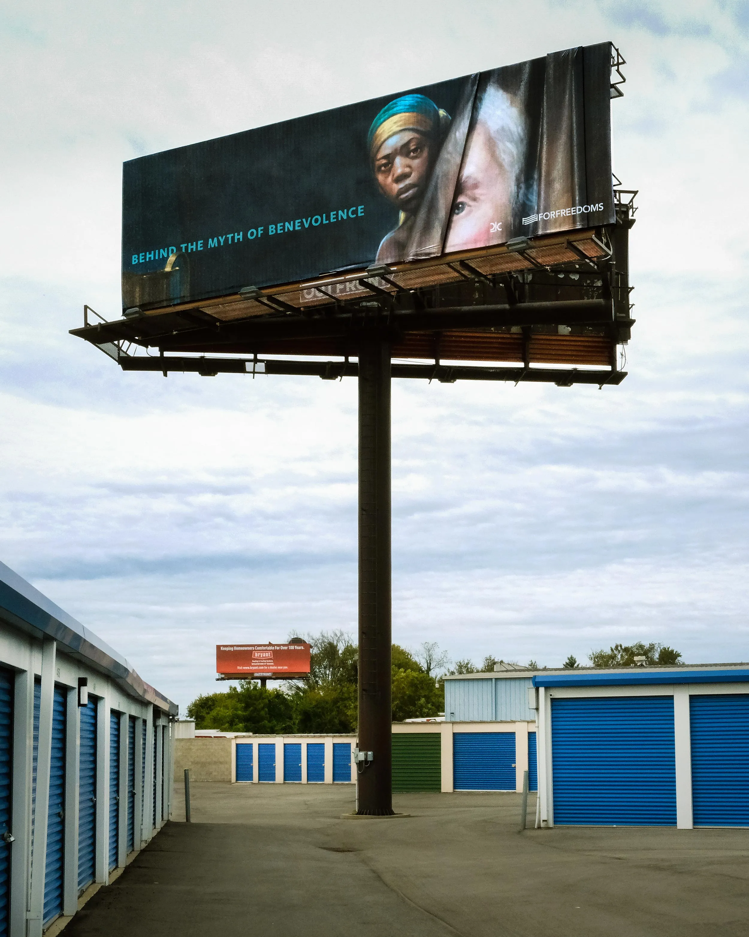 A billboard in the middle of storage units.