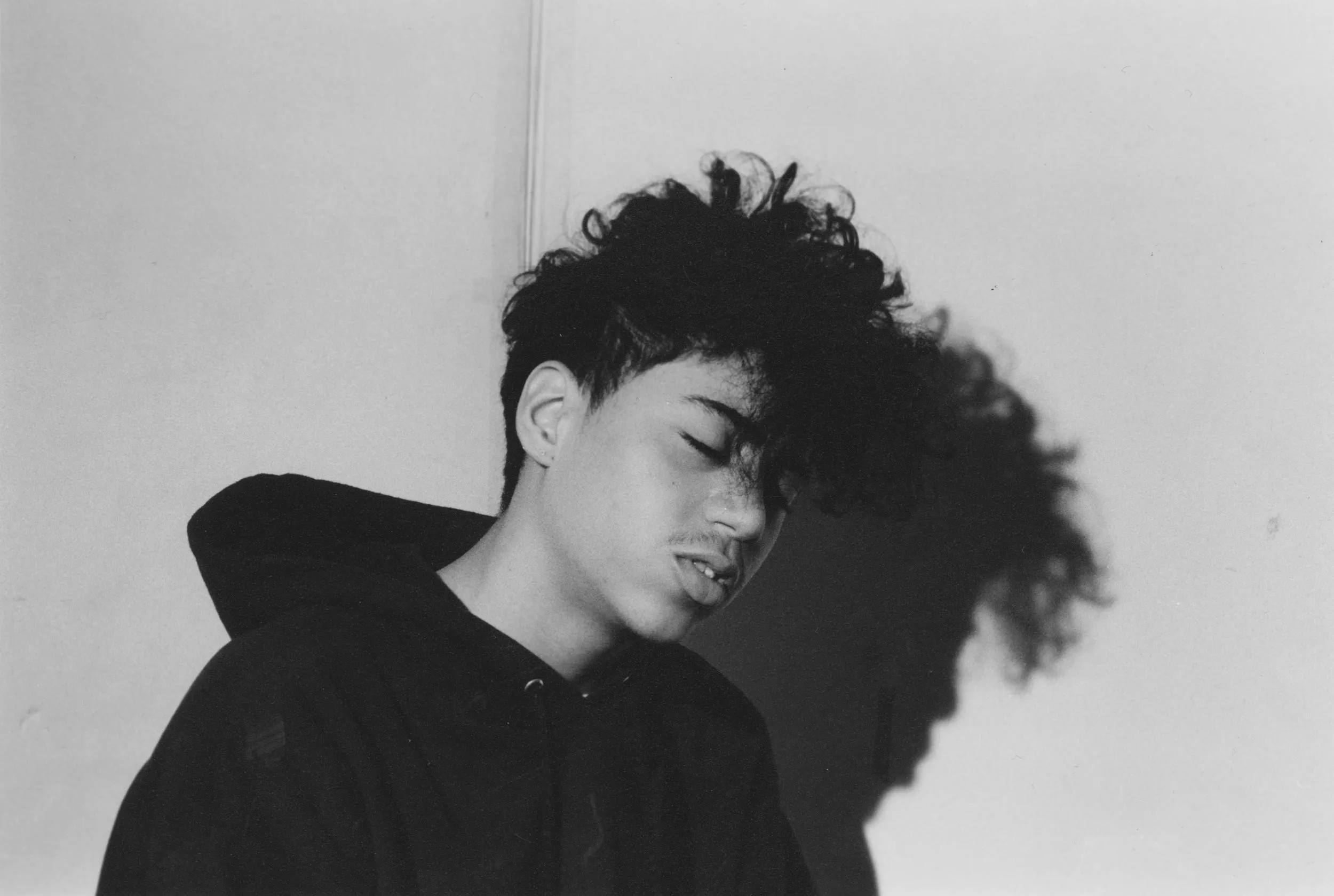 Black and white image of a kid in a corner