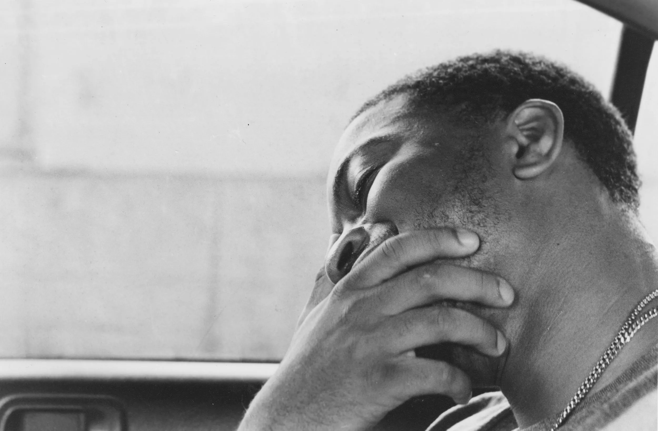 Black and white closeup image of a guy inside a car