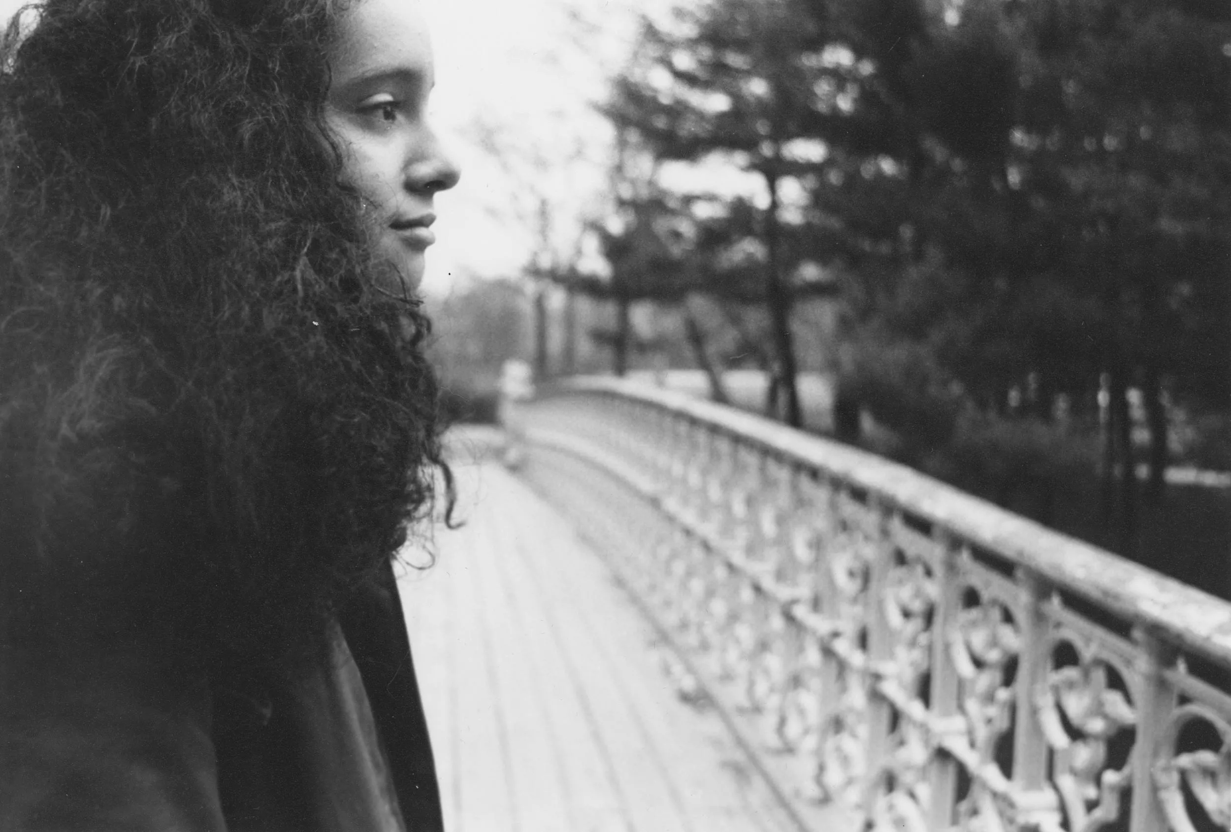 Black and white closeup image of a girl on the bridge