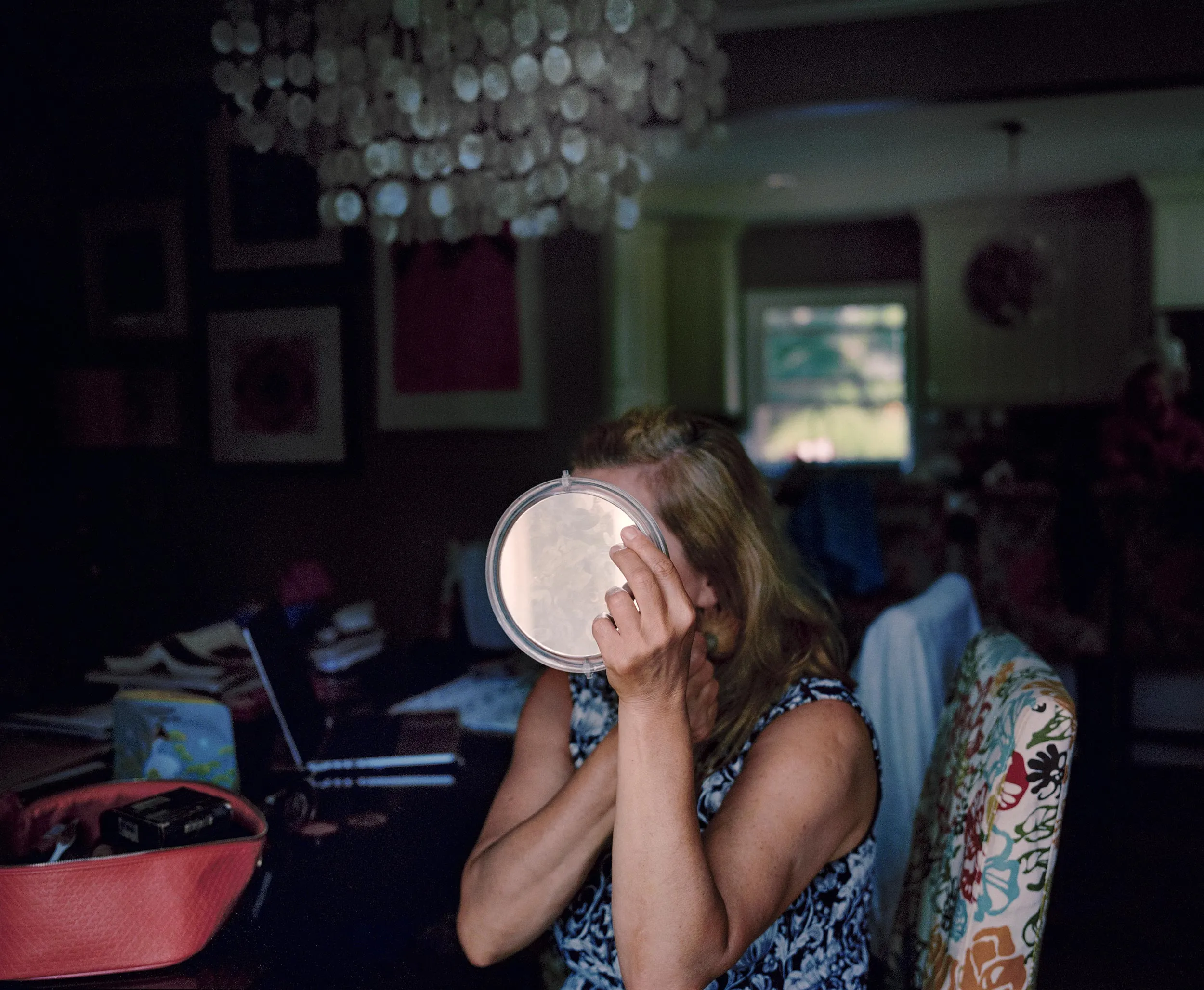 Woman looking in a hand mirror
