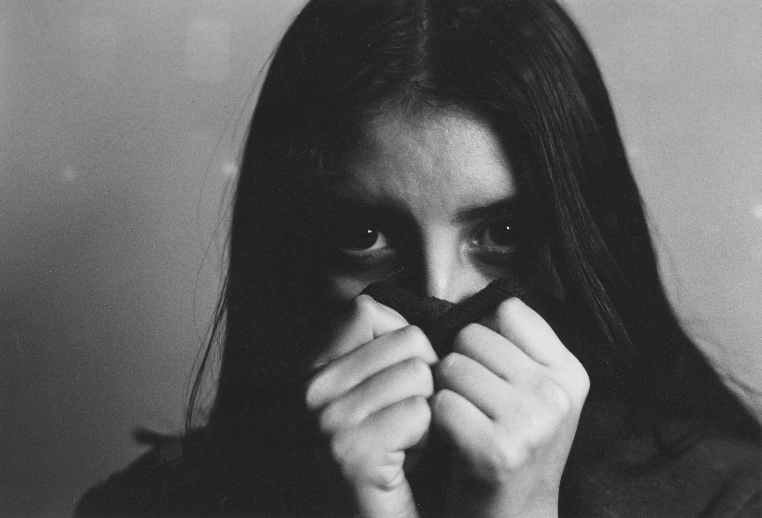 Girl covering her mouth with her shirt