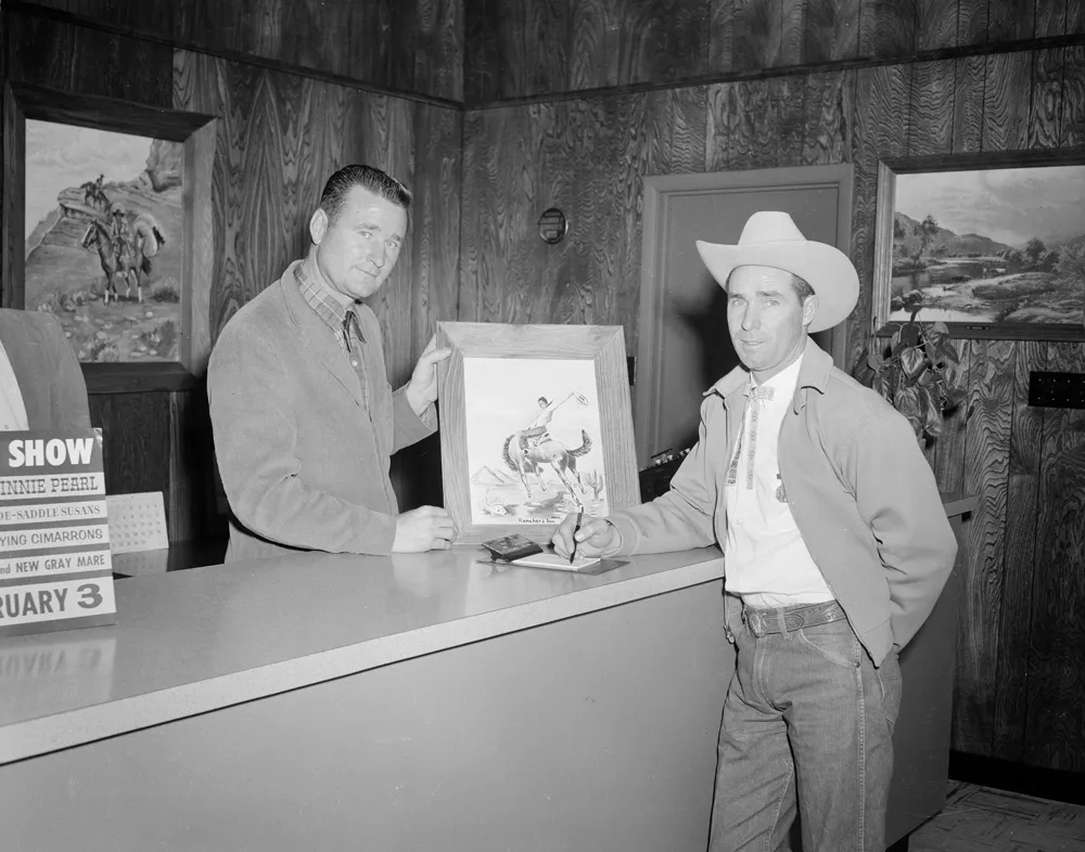 Two man holding a painting.