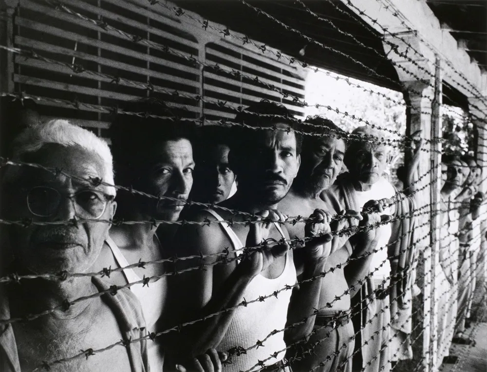 A group of people behind barbed wire.