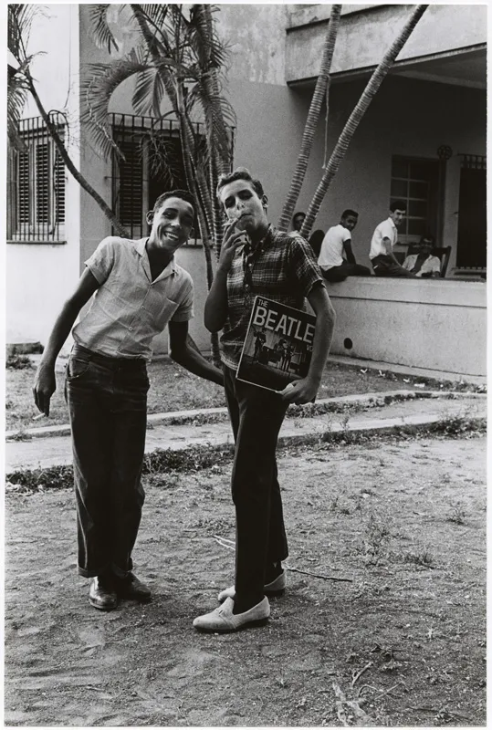 Two people holding a Beatles album.