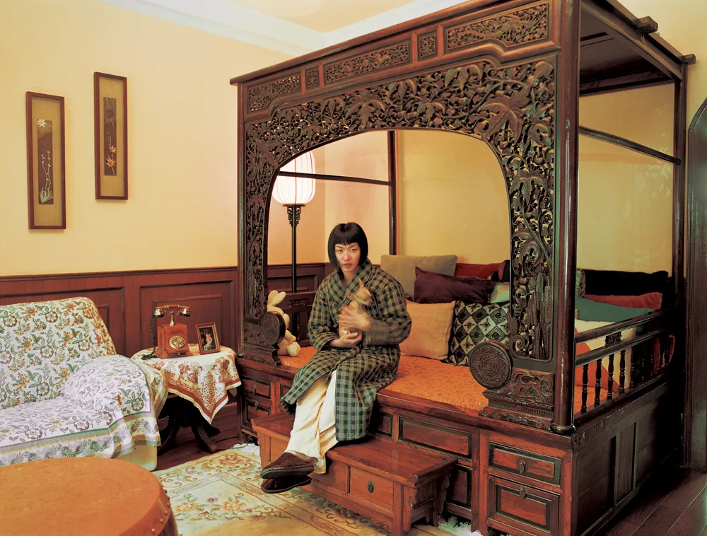 Woman sitting in bed holding a dog.