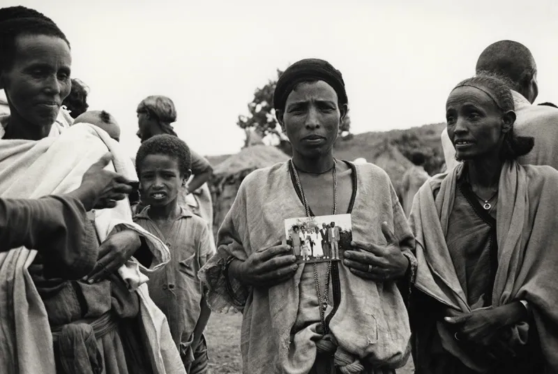 Someone in their rural village holding a photograph. 