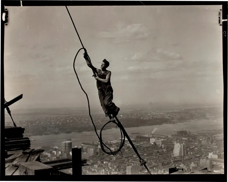 A construction worker dancing off of a cable high above NYC. 