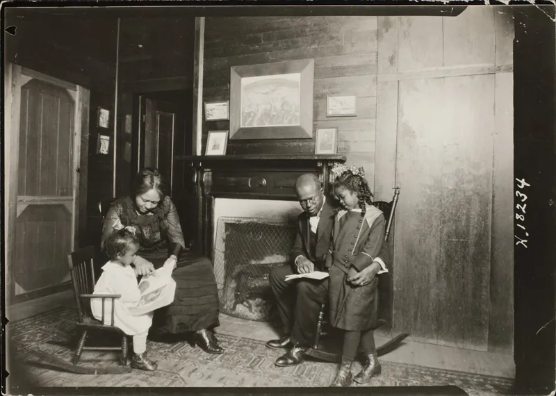 A black family from the 19th century reading together. 