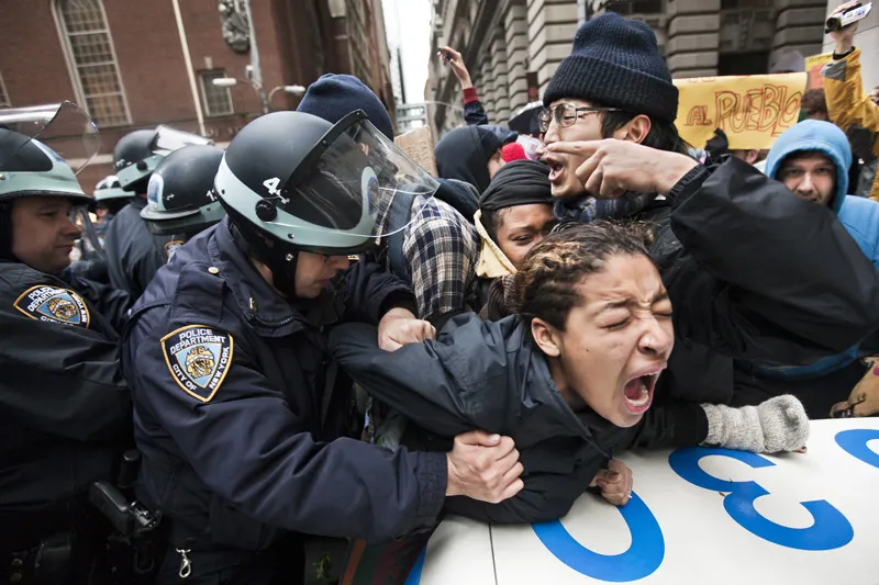 Five NYPD cops slamming an unarmed women against the hood of a police cruiser. 