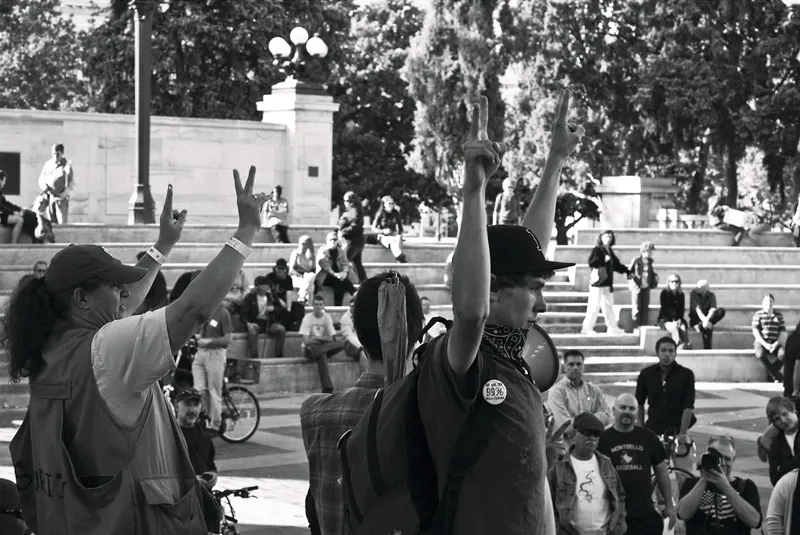 Protestors with their hands raised, flashing the peace sign. 