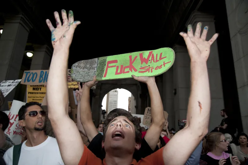 Protesters with a sign that says, "Fuck Wall Street".