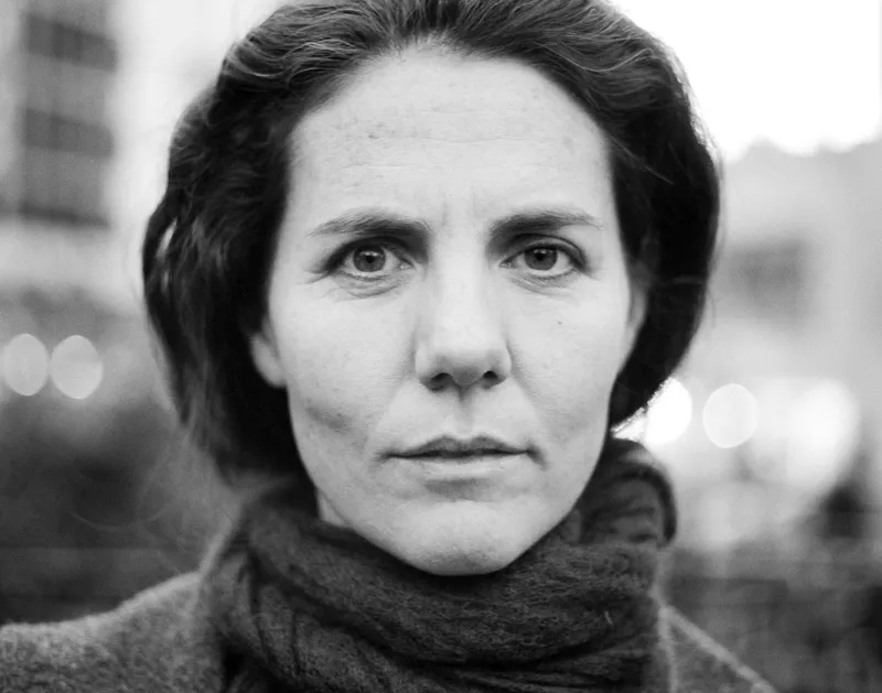 The facial profile of a gaunt women with her hair tied back.