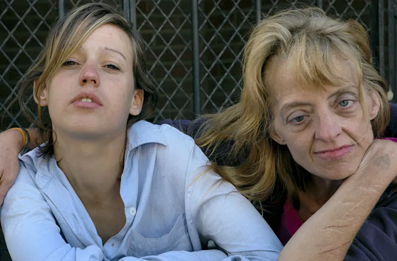 A two women, one neurotypical and one with a mental disorder sit down in front of the camera. 