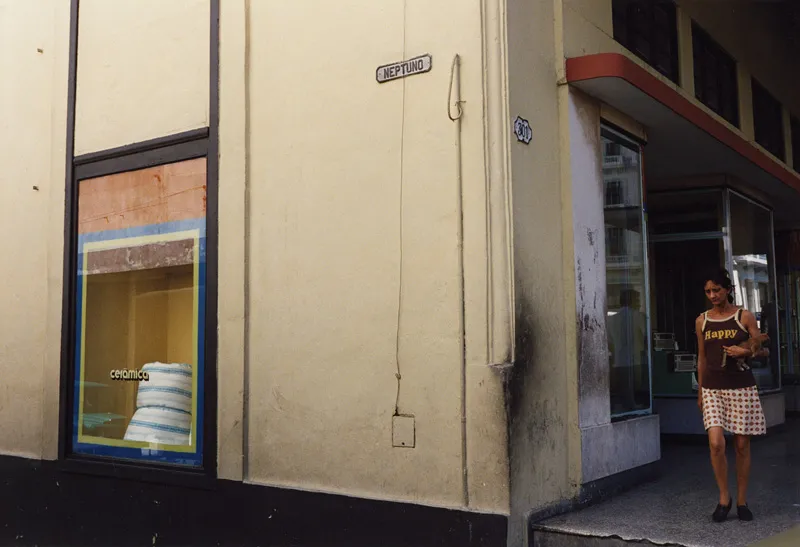 A woman at the corner of a city street.