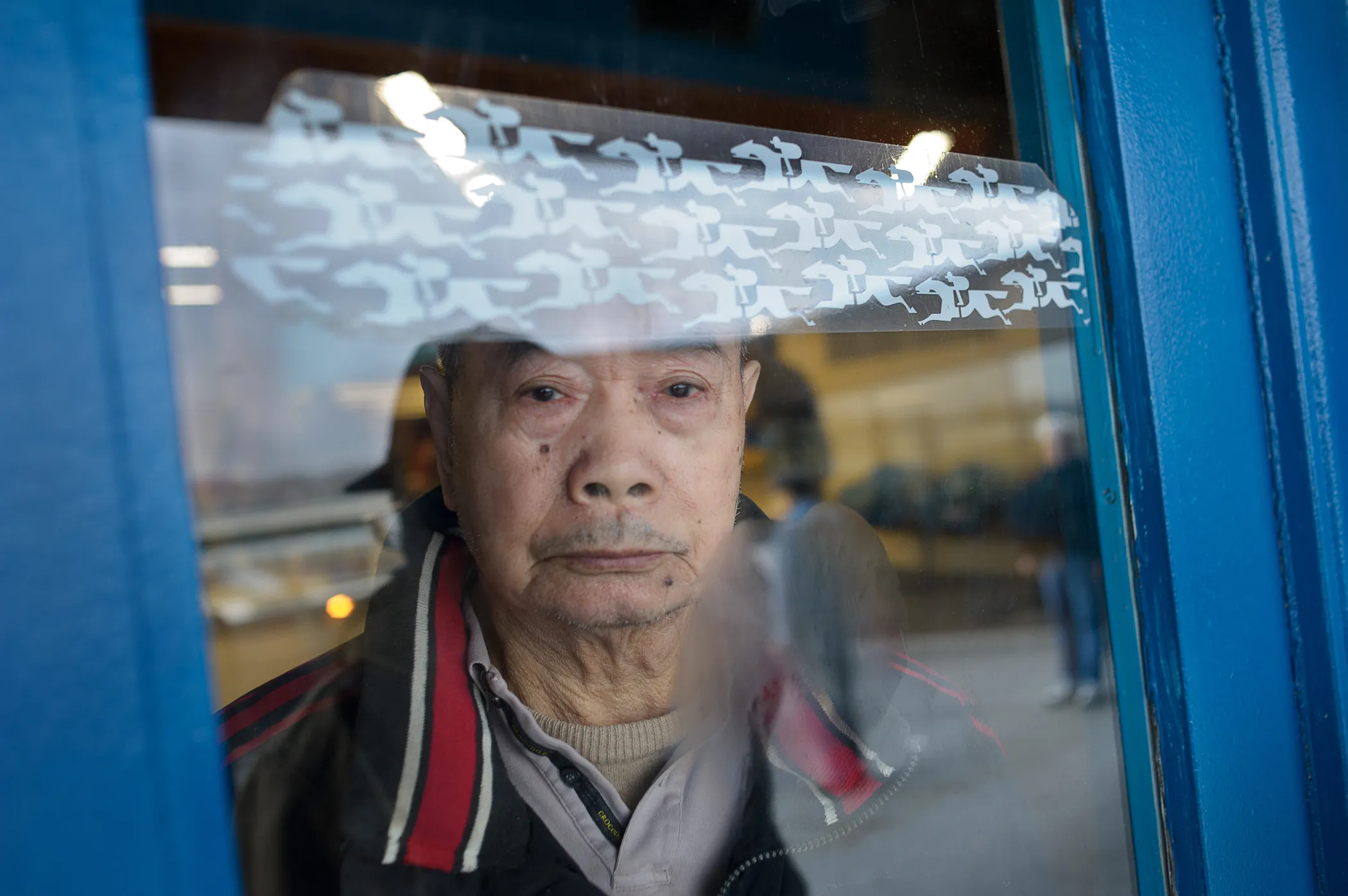 Old man starting out a window