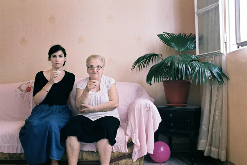 Two women sitting on a couch inside a house