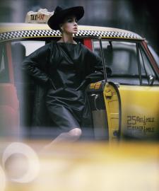 A woman next to a taxi.