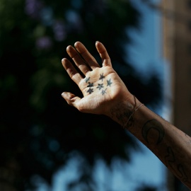A hand with star tattoos. 