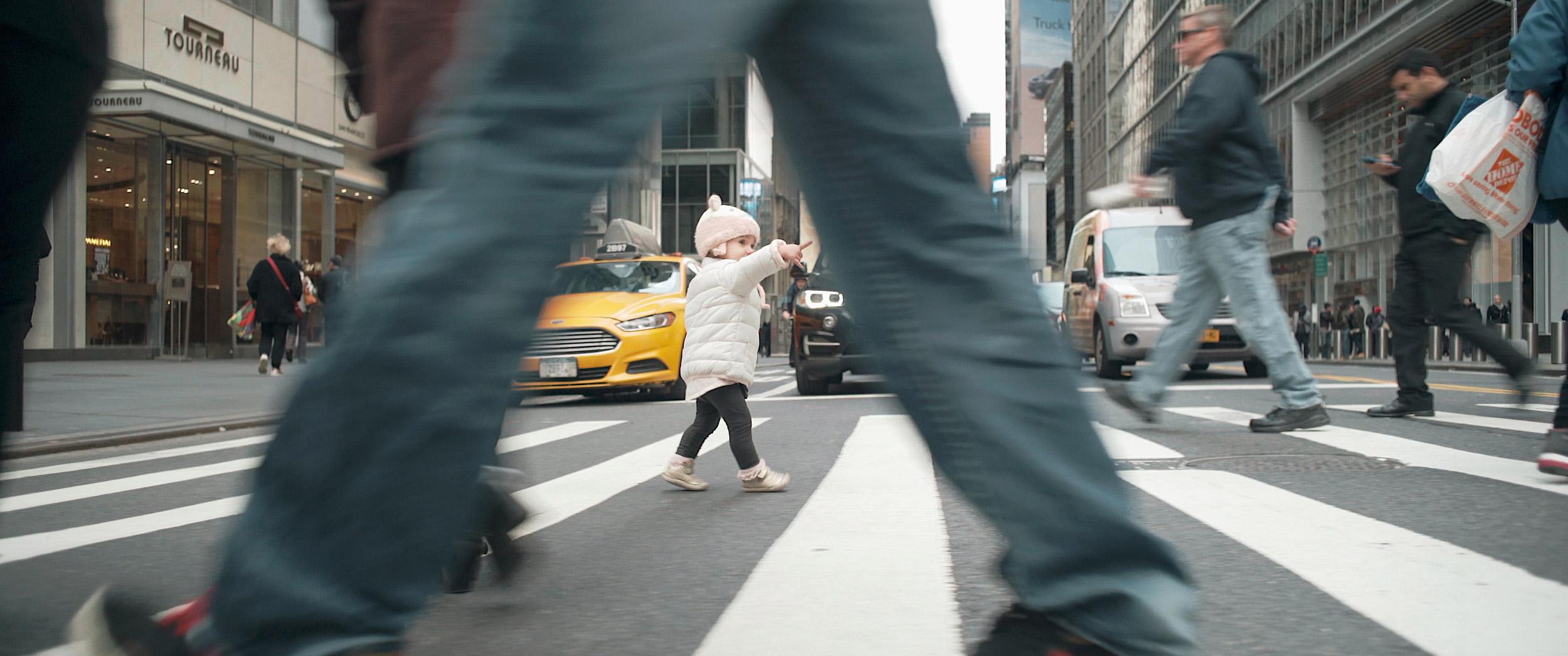 A baby crossing the street.