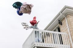 Someone throwing clothes over a balcony.