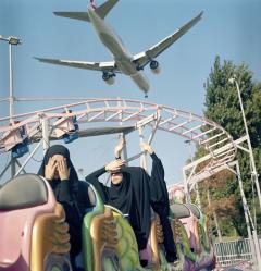 Sabiha Çimen A plane flies low over students riding a train at a funfair over the weekend