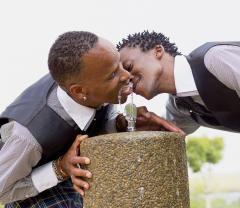 Two people kissing and drinking water.