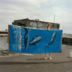 A woman hanging a dolphin blanket.