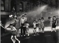 A black and white photo of kids playing in the streets. 