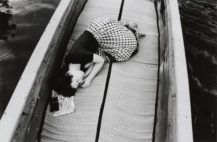 A woman sleeping in a boat. 