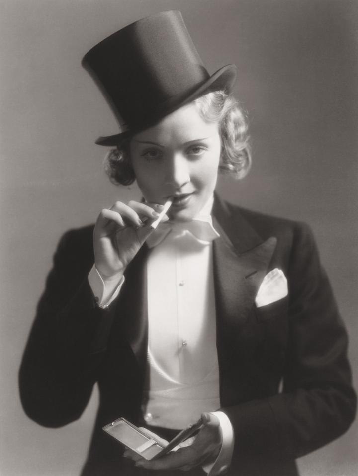 Dietrich in a tuxedo and a top hat with a cigarette in her mouth. 