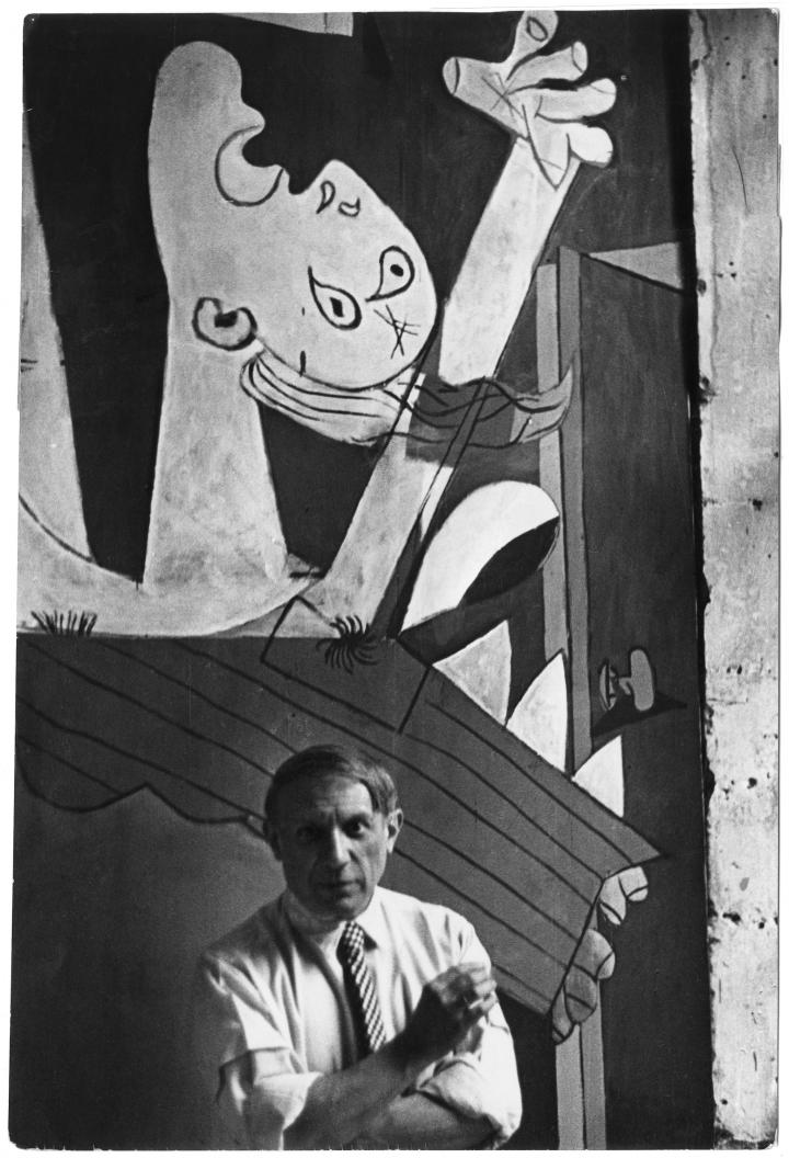 Picasso standing in front of his abstract art.