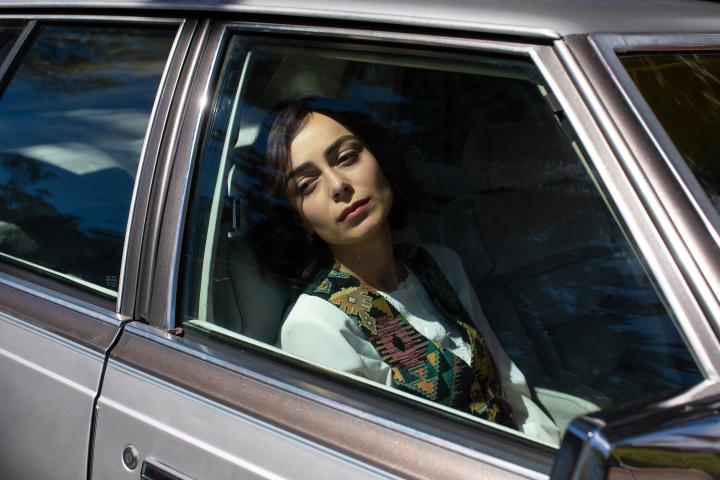 A girl sitting in the passenger seat of a car.