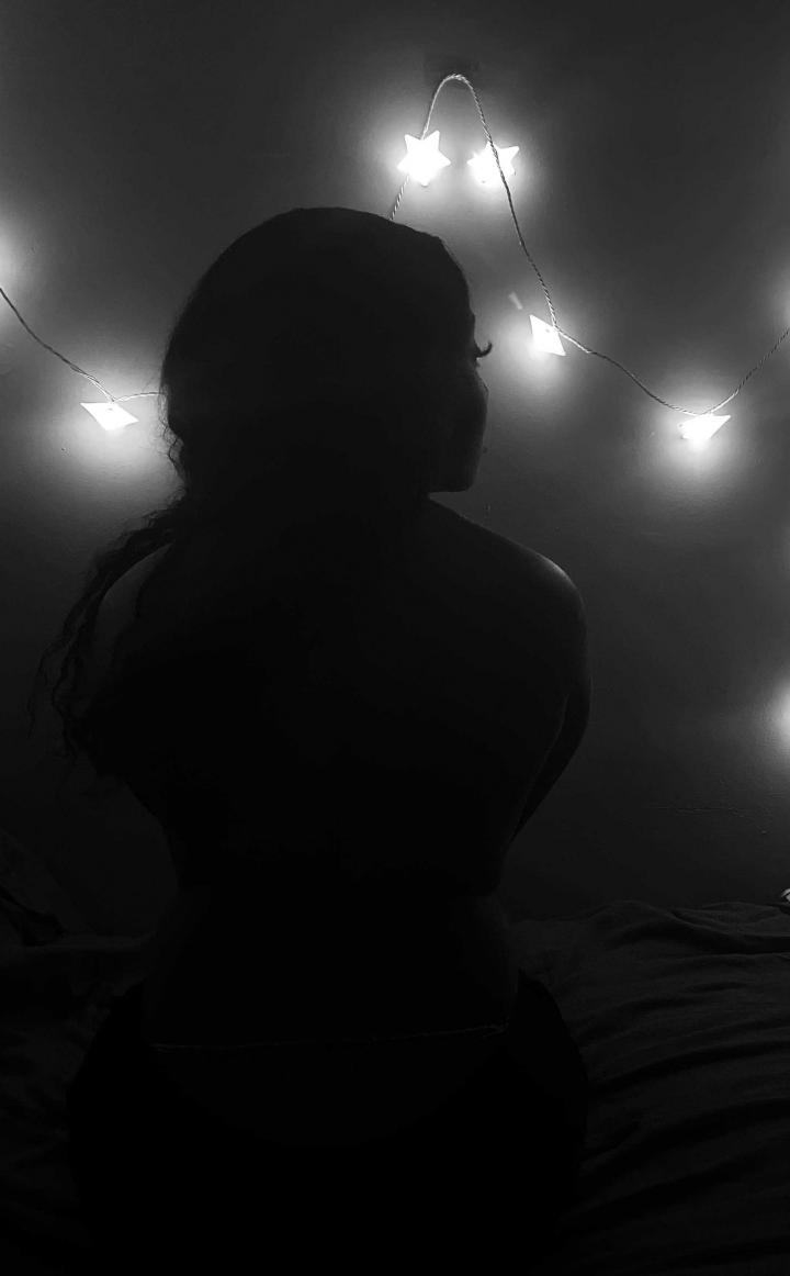 A woman's backside, with the sole lighting of fairy lights. 