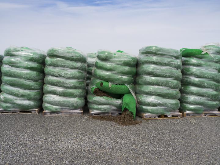 Stacks of fertilizer bags, with one bag ripped open on the side. 