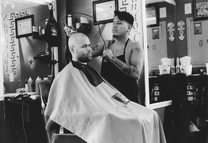 A man in a barber shop having their head shaved.
