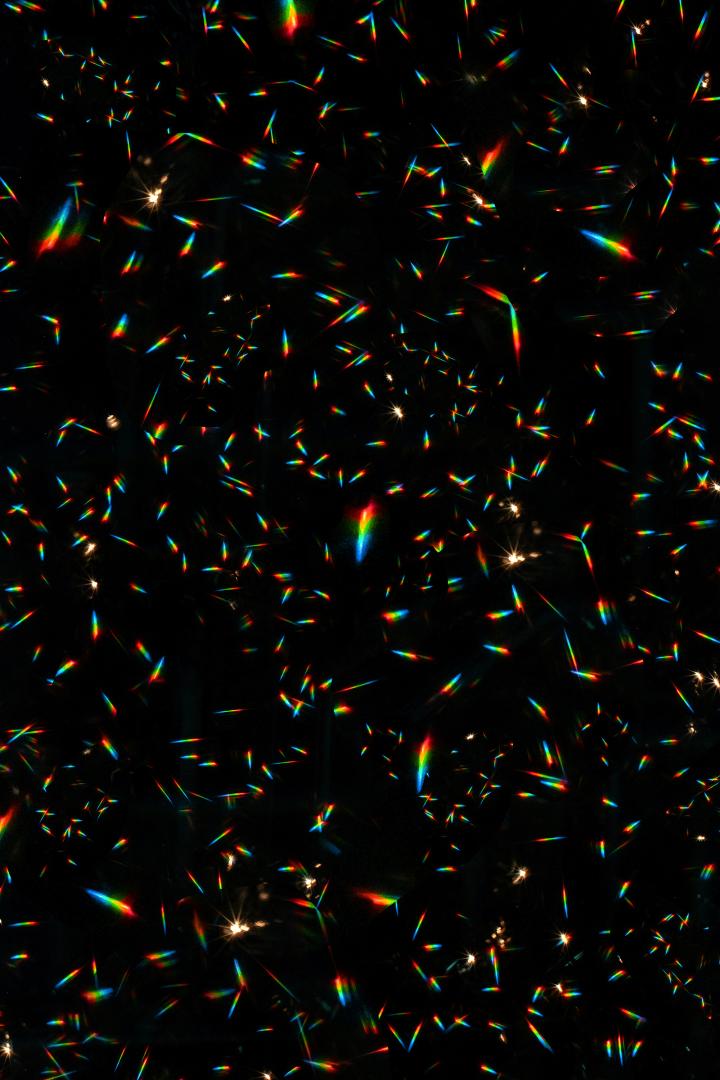 A display of rainbow light reflections with an otherwise pitch black background.  