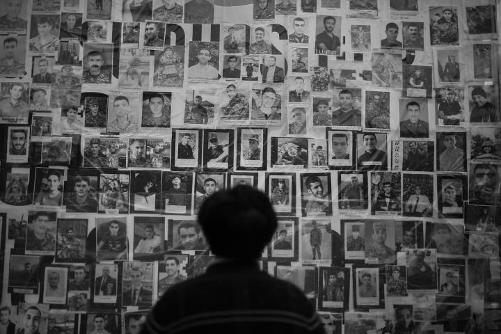 The back of a man's head as he looks at a wall of profiles. 