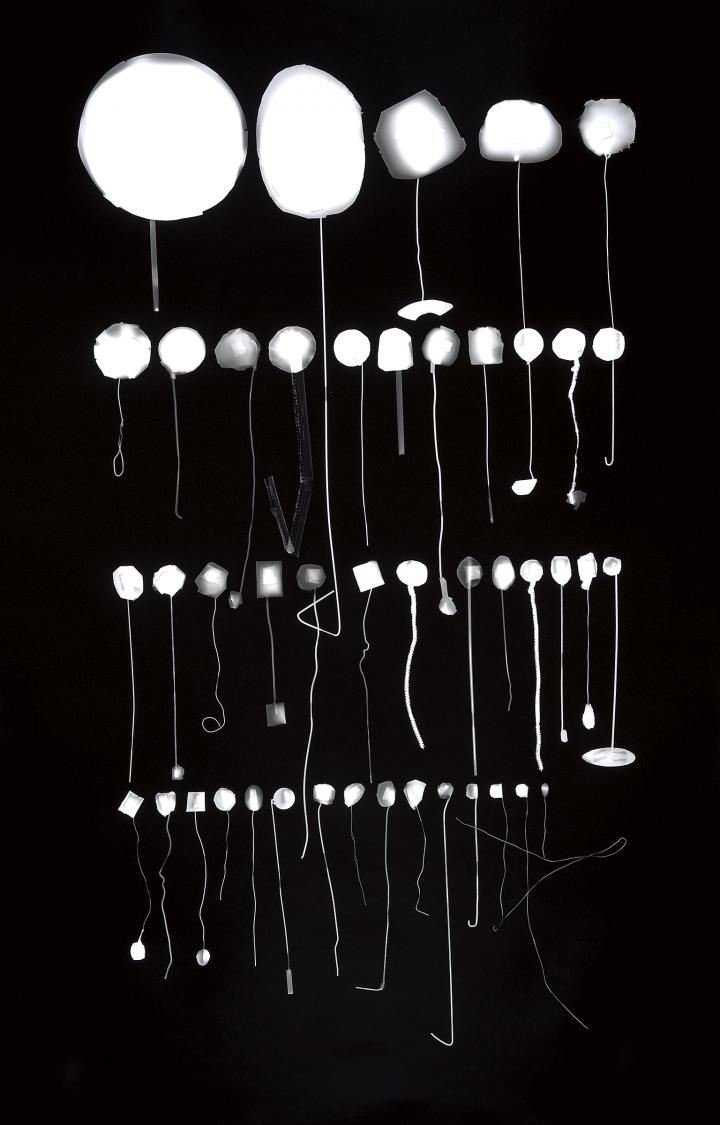 Rows of white balls attached to their respective piece of string, the balls getting progressively smaller. 