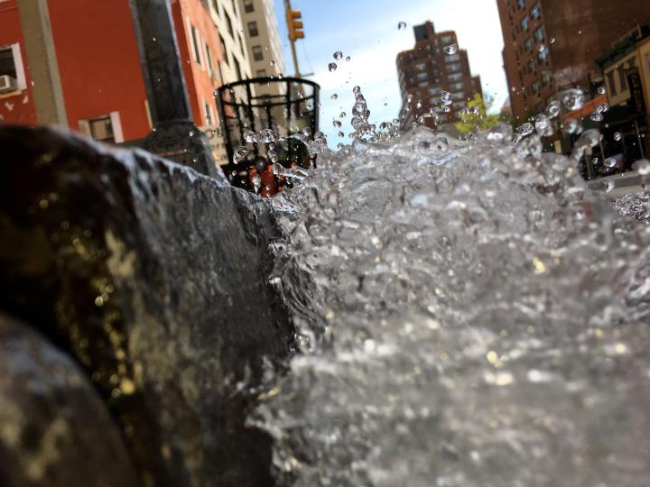Water being splashed against the side of the sidewalk.