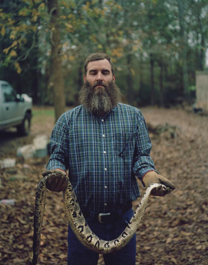 A man holding a snake. 