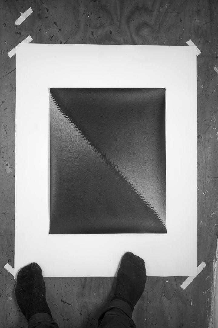 Black and white image of a painting on the floor