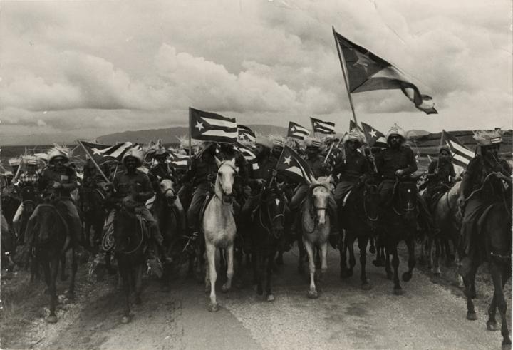 A group of soldiers on their horses waving their national flag.