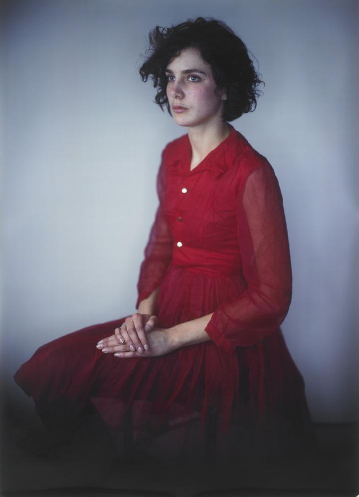 A women sitting in a red dress.