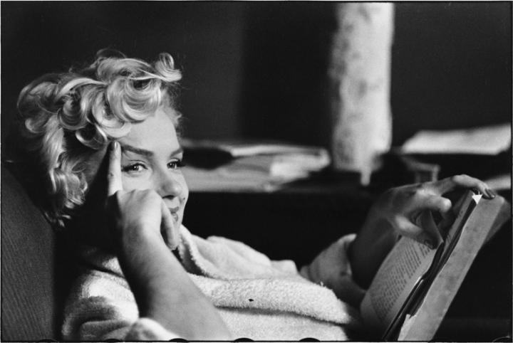 Marilyn Monroe looking up from a book. 